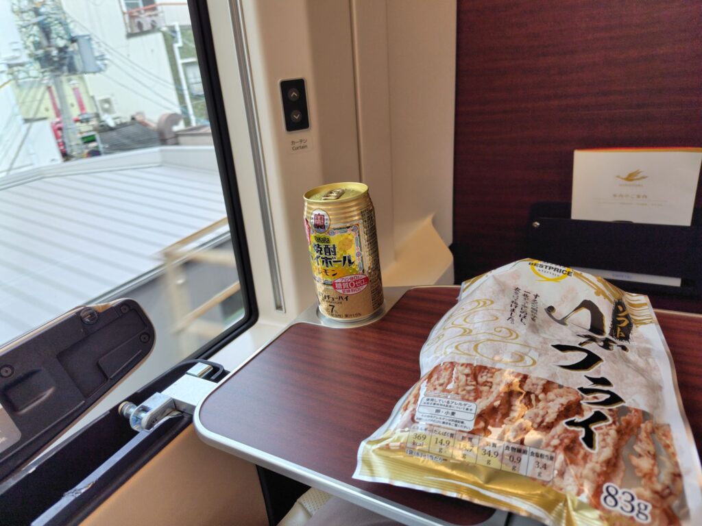 特急ひのとりの車内テーブルに置いた、乾きもののイカのおつまみとレモン風味のハイボール